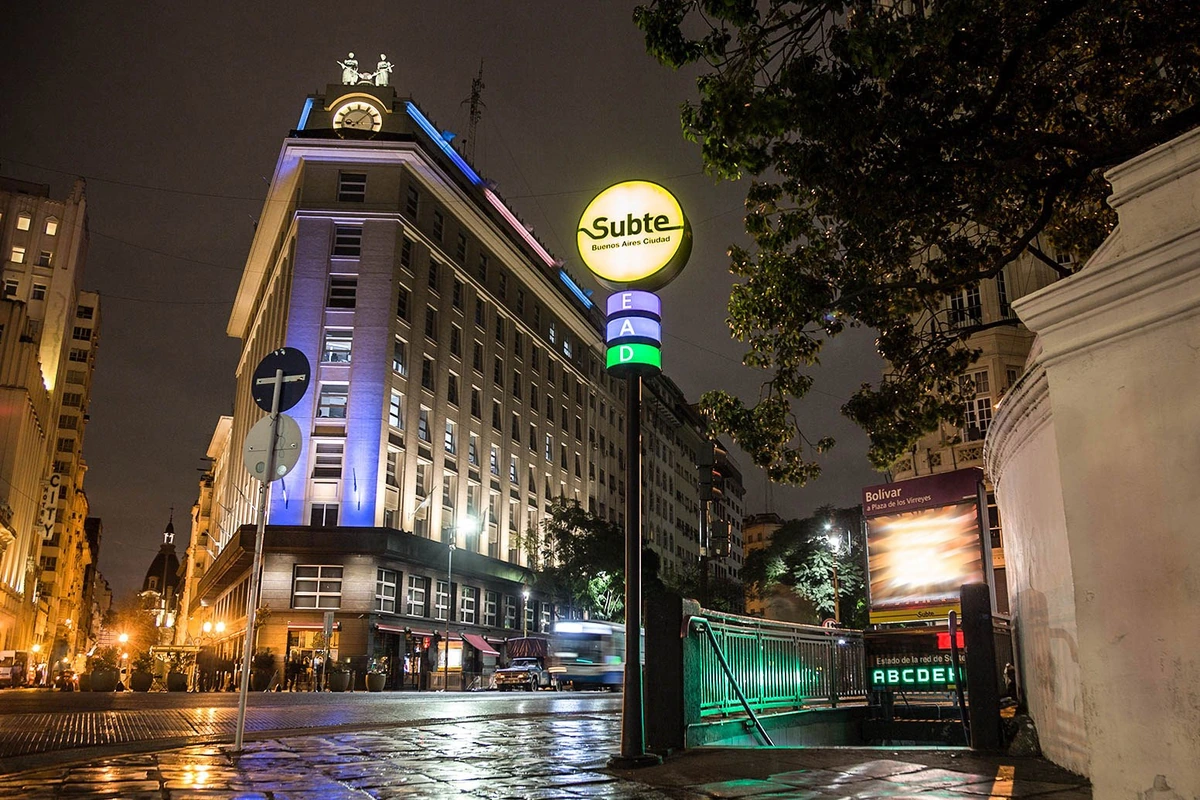 Passengers waiting beside a colectivo stop on a broad Buenos Aires avenue